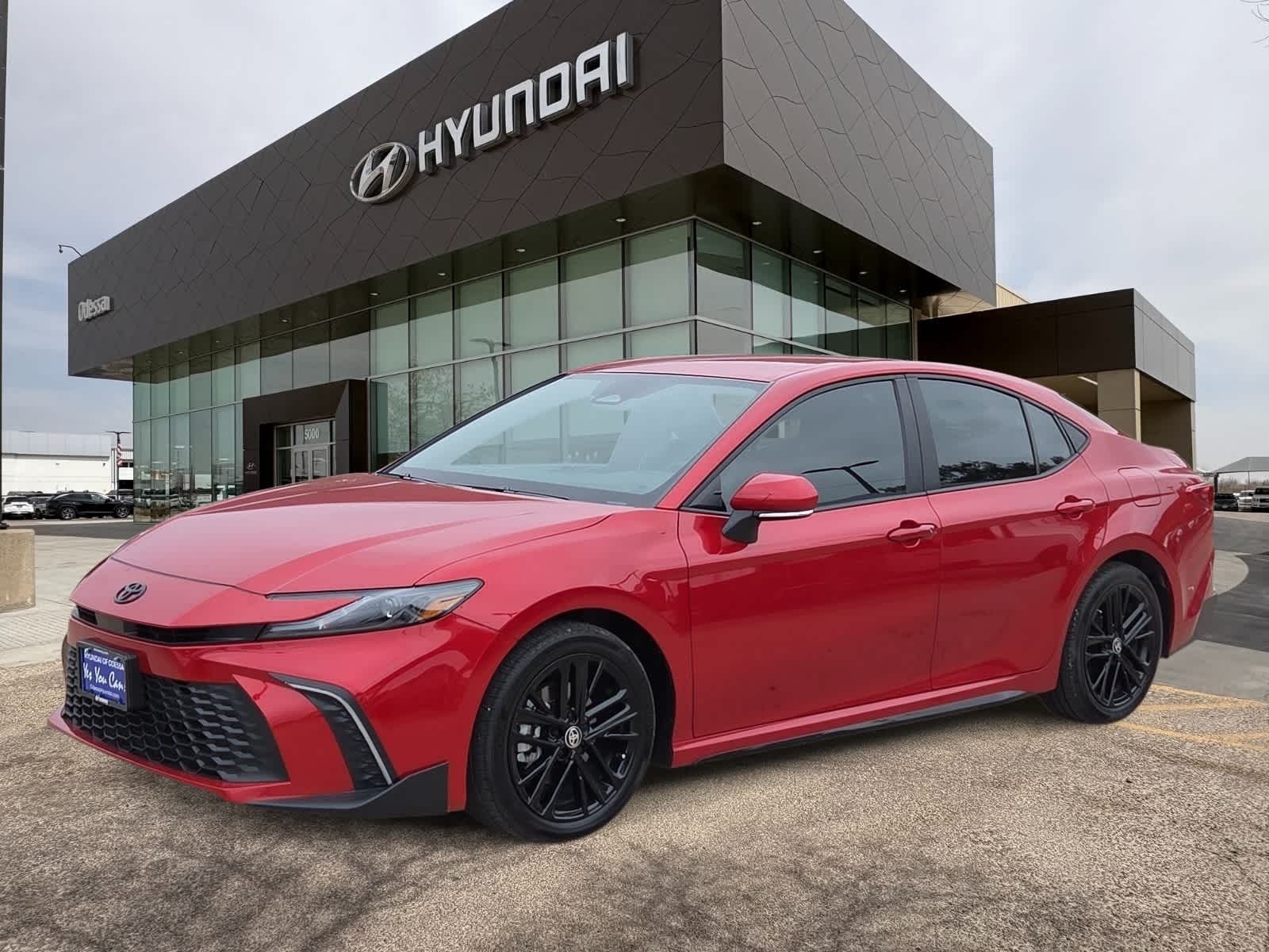 2026 Toyota Camry SE in Supersonic Red — front three-quarter view